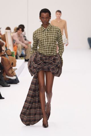 Woman in plaid shirt and skirt