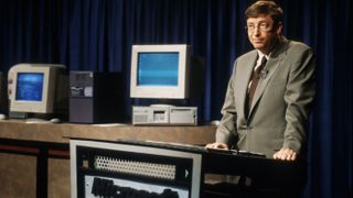 Bill Gates standing sheepishly at a presentation for Windows 98