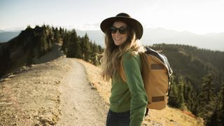 Woman hiking wearing hat and sunglasses