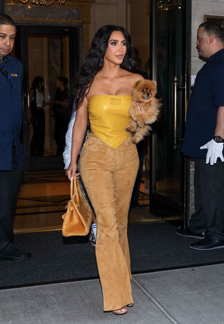 Kim Kardashian is seen leaving The Ritz-Carlton on August 14, 2024 in New York City wearing a mustard miu miu bandana top and an hermes birkin