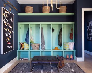 mudroom with blue storage unit with stalls, foot stool and storage shelf - Andrea Schumacher