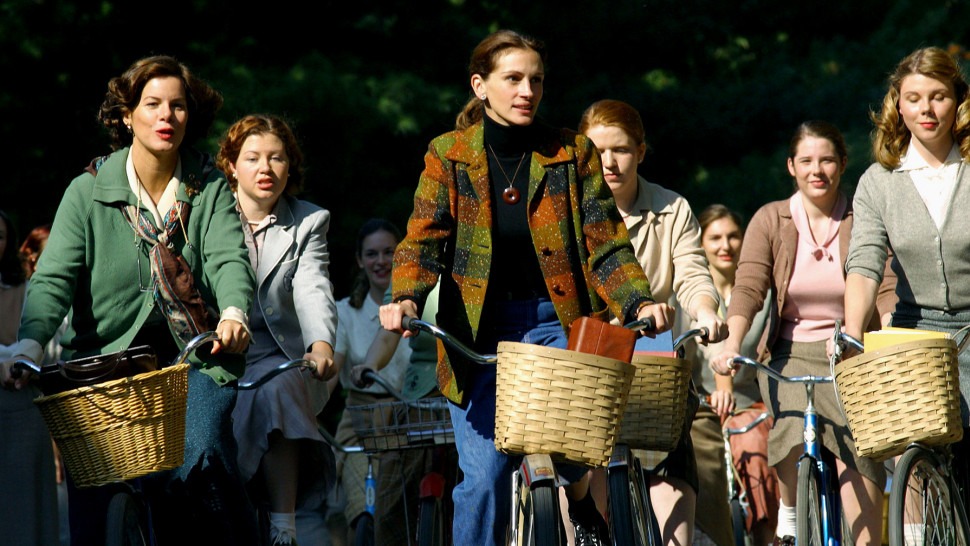 Julia Roberts rides a bike with a basket among a group of women