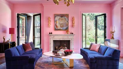 living room with barbie pink walls blue sofas and fireplace