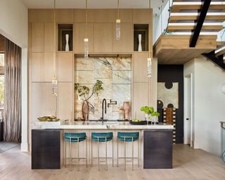 Double height kitchen with marble backsplash and island