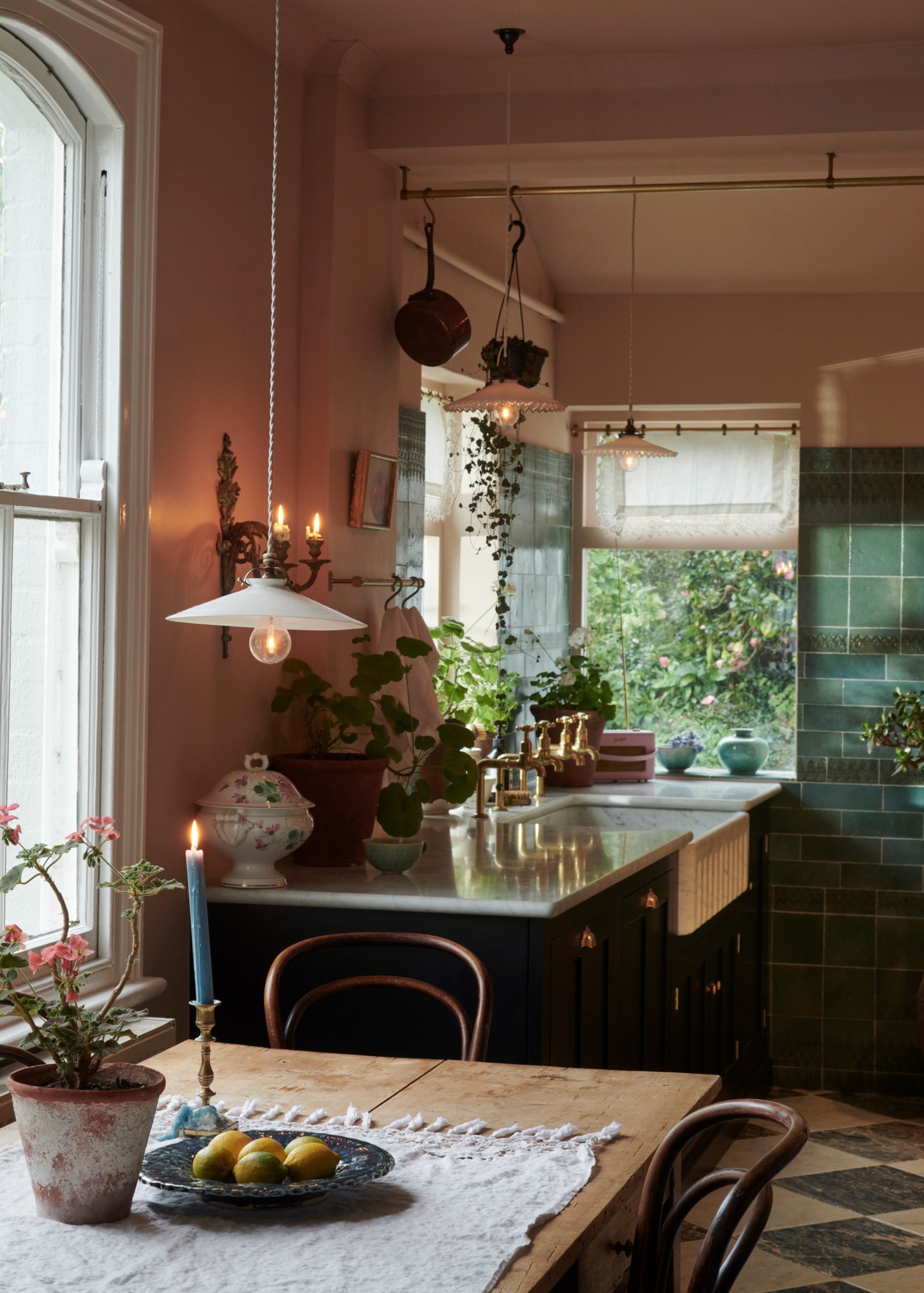 Hele Parker, Creative Director's Victorian Villa by deVOL. A traditional kitchen in pink with green tiles, layered lighting and candlelight.