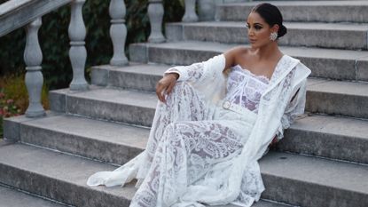 Jessel Taank smiles in a white lace dress 