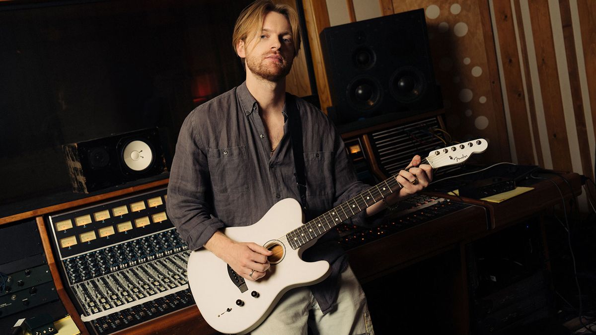 Finneas holding a Fender Acoustasonic guitar in the studio