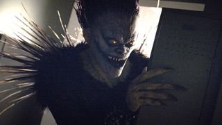 Willem Dafoe's Ryuk peers menacingly from behind a door in Netflix's Death Note movie