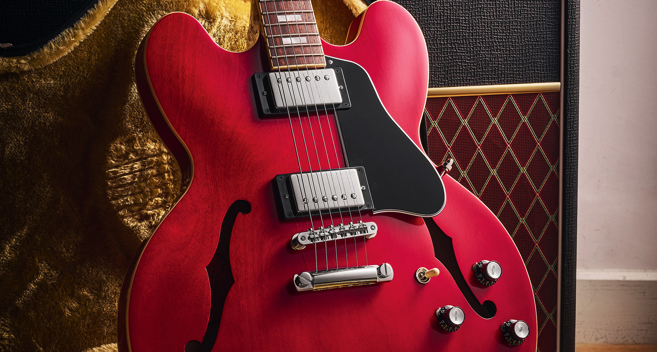 Epiphone Inspired By Gibson Custom 1962 ES-335 Reissue: the handsome semi-hollow electric is finished in Sixties Cherry and is photographed against various backgrounds.
