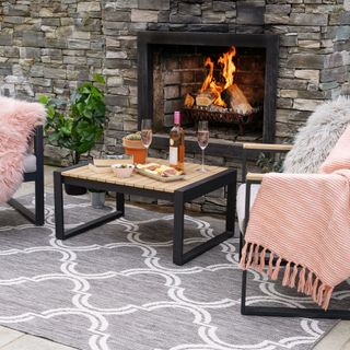 patio with outdoor rug firepit and throws and blankets on chairs