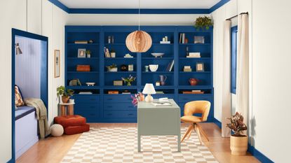 home office with dark blue built in cabinetry and white walls