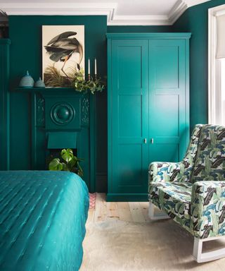 A teal bedroom with matching master closet and palm print chair