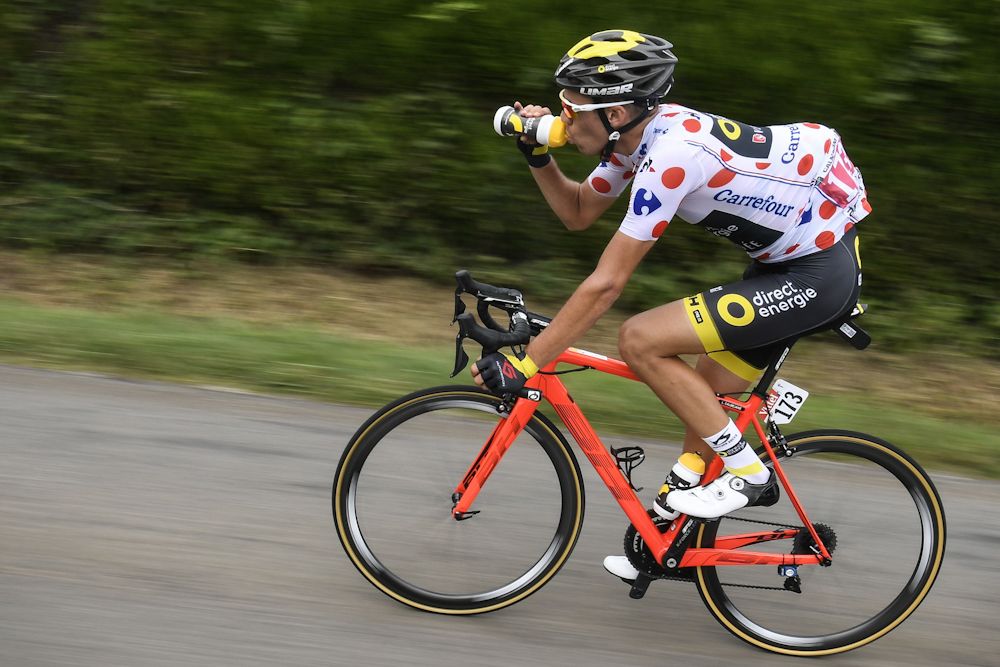 Lilian Calmejane wearing the best climber's polka dot jersey drinks as he rides
