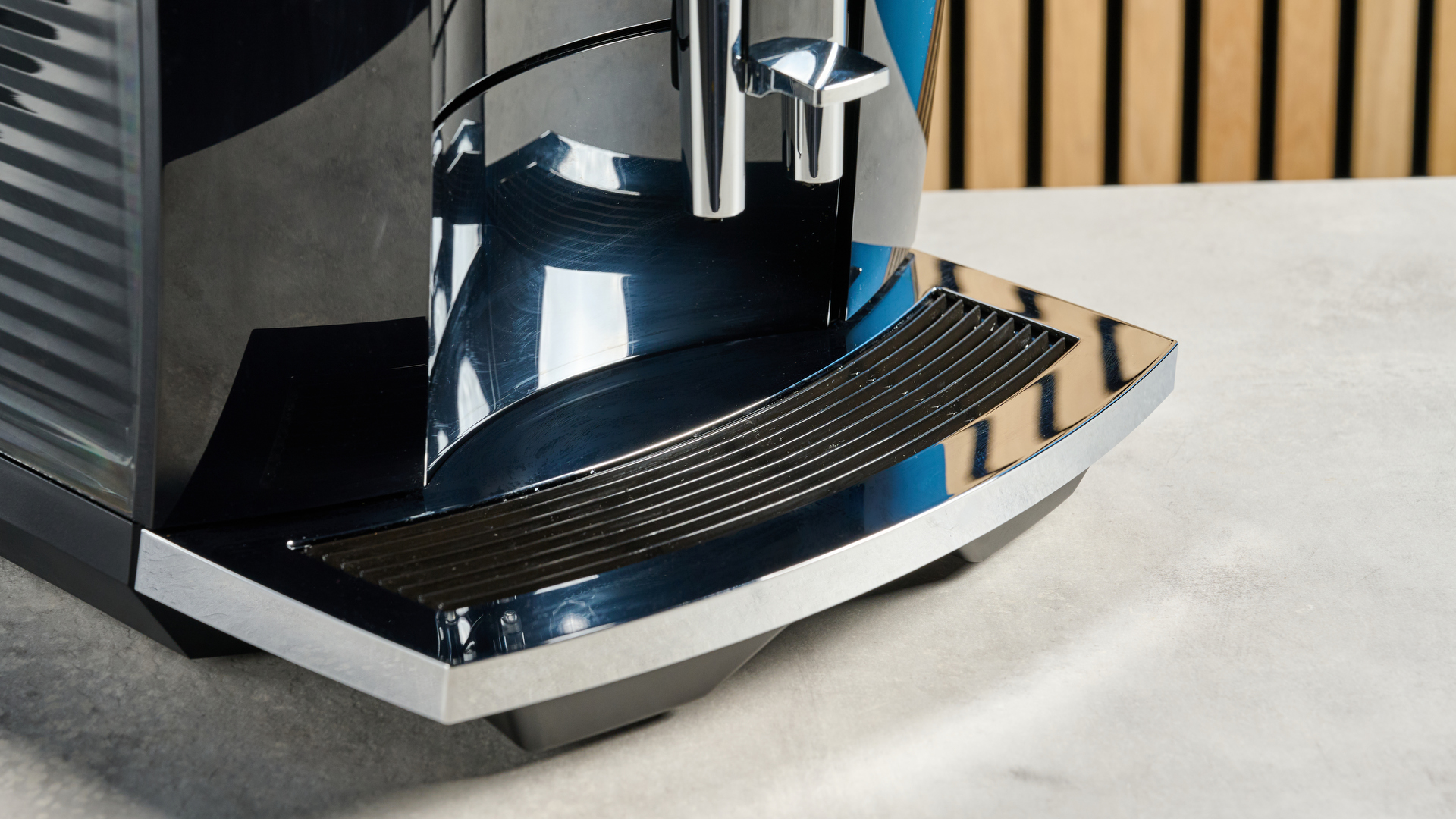the jura E8 automatic coffee machine in piano black with a 64 ounce water tank, screen, and jura logo on the front