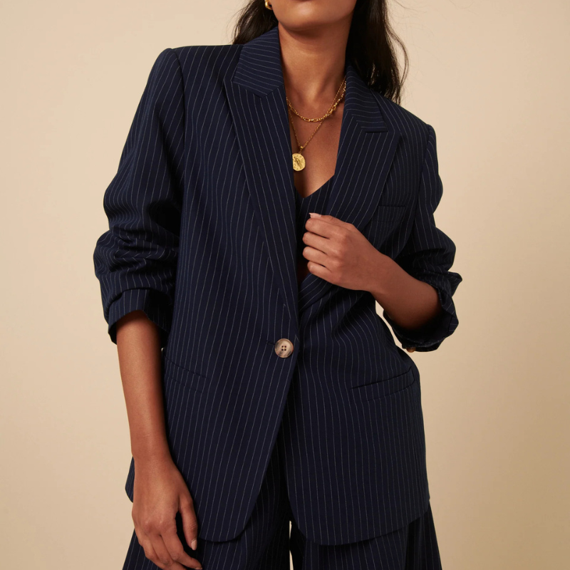 A woman wearing a navy pinstripe blazer