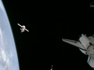 This still from NASA TV shows the Russian Soyuz TMA-20 spacecraft (left) as it backs away from the International Space Station. The shuttle Endeavour's aft section is visible at right.