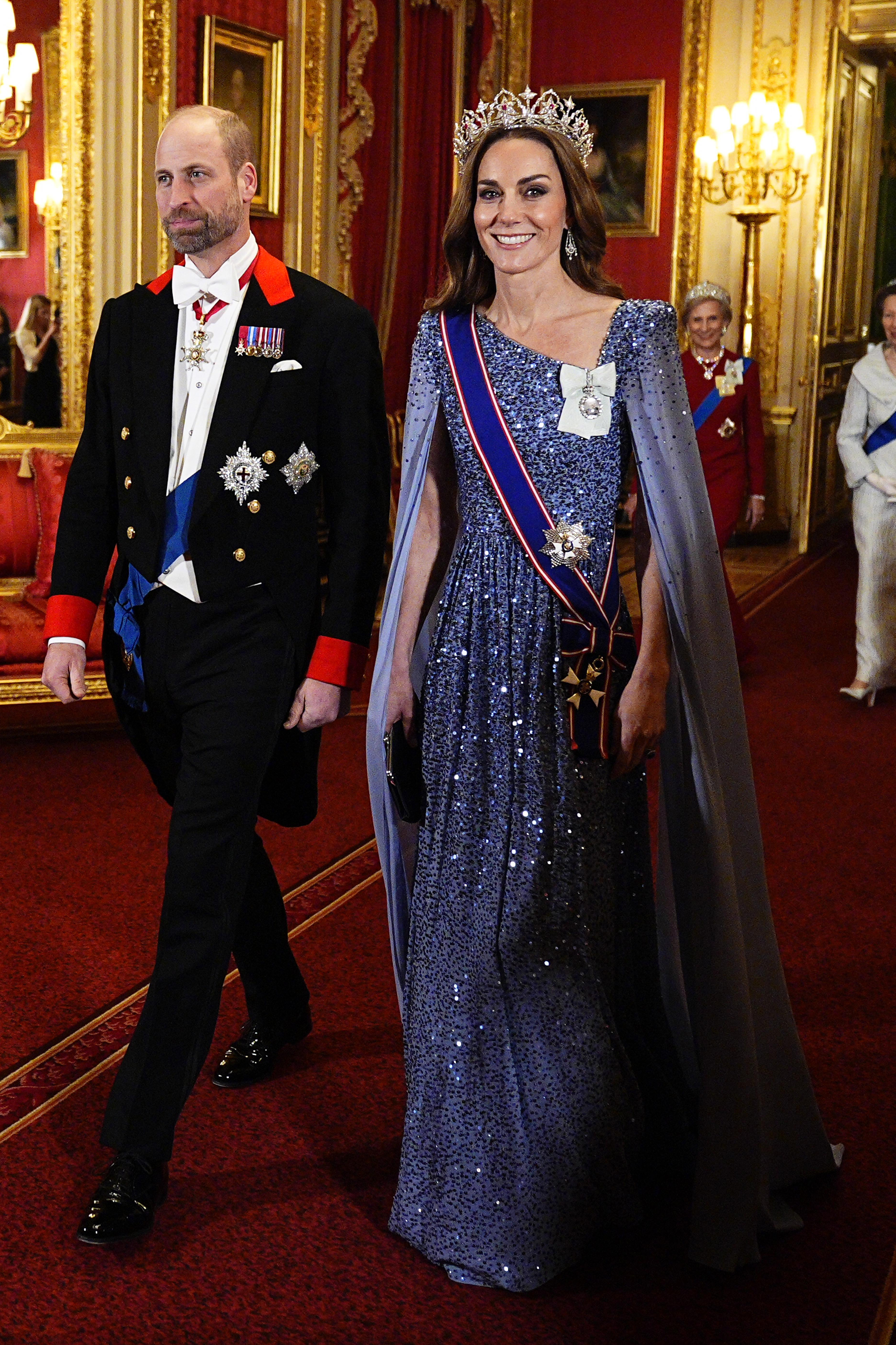 Princess Kate wearing a blue gown and tiara walking with Prince William