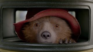 Paddington Bear (voiced by Ben Whishaw) hiding in a bin in Paddington 2