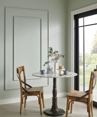 dining room with gray-green walls, glass door and round table and two chairs