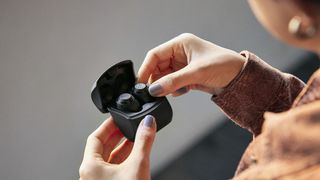 someone opening the audio-technic ath-cks50tw wireless earbuds charging case