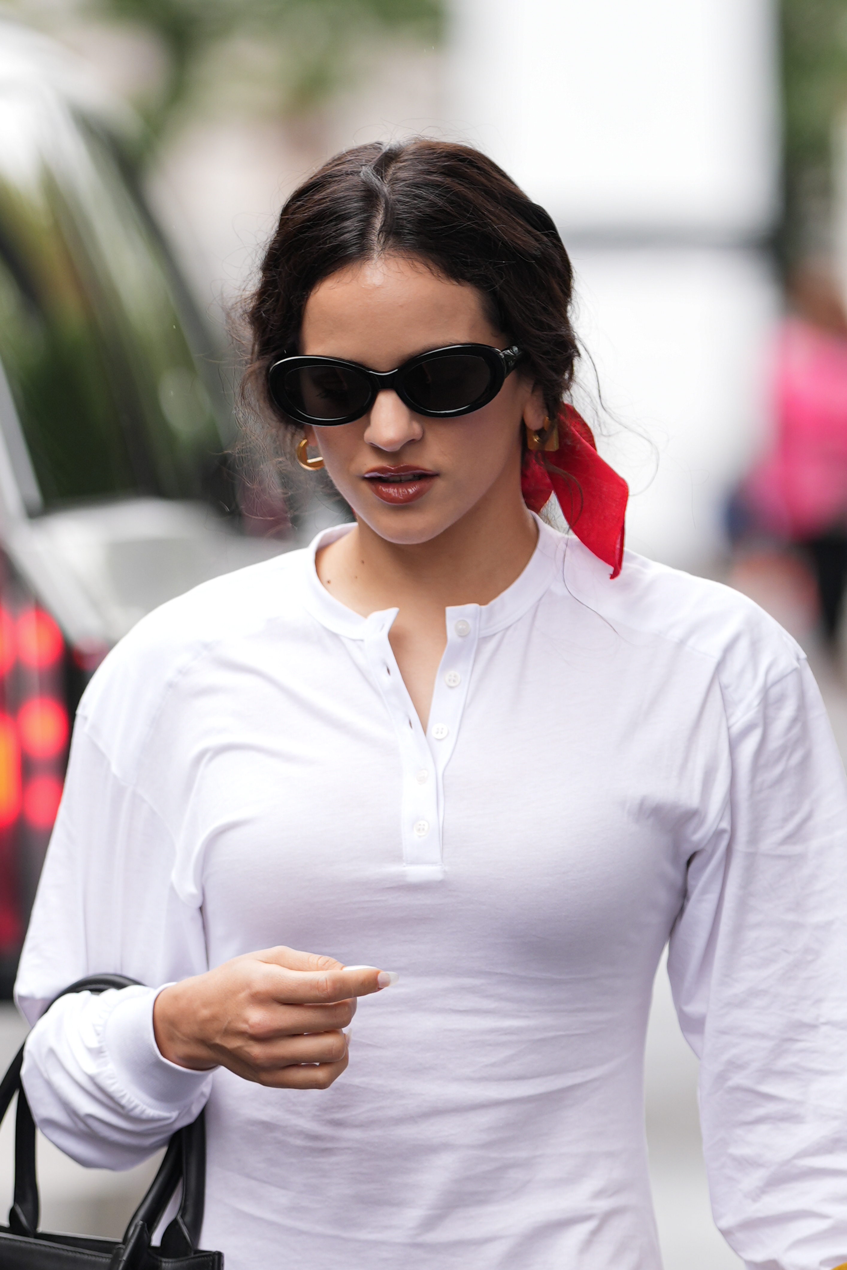 Rosalía in a white shirt with dark sunglasses