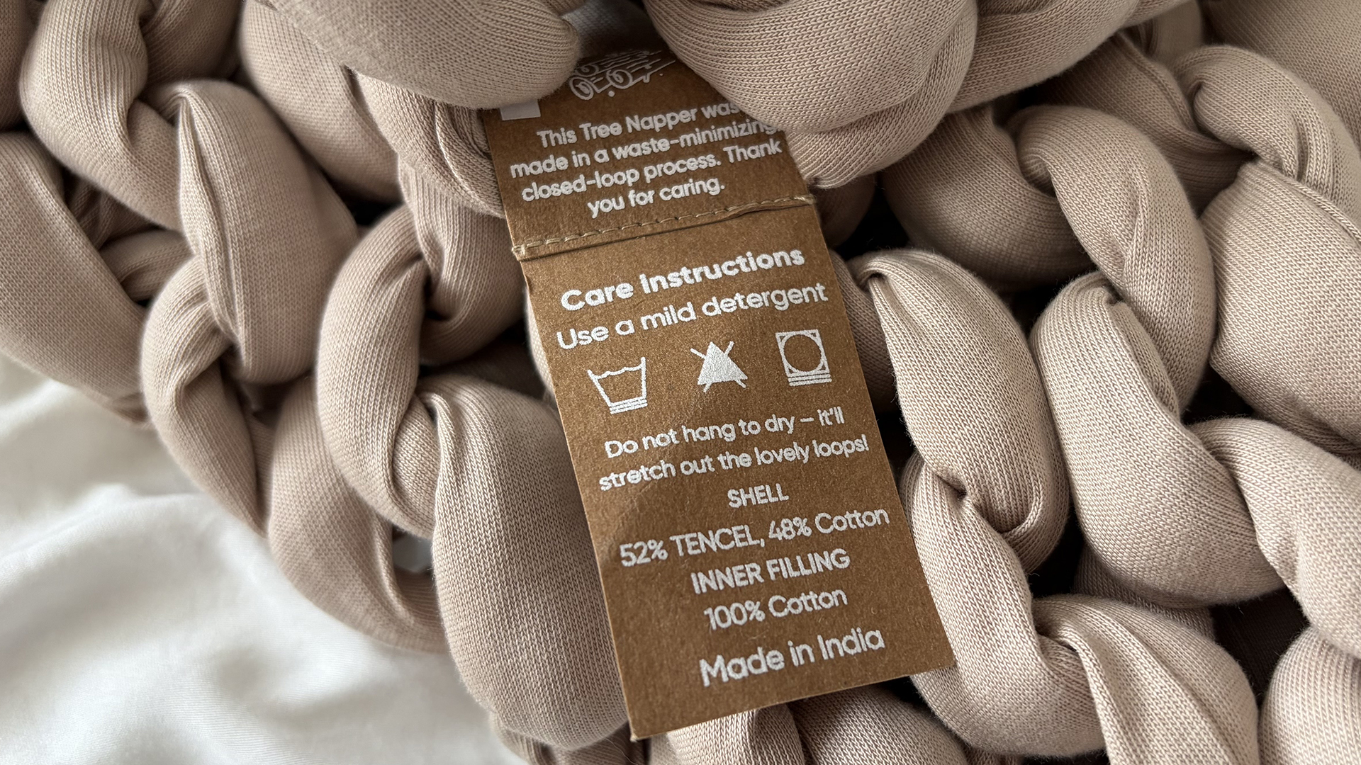 A close up of the care instructions tag for the Bearaby Tree Napper Weighted Blanket