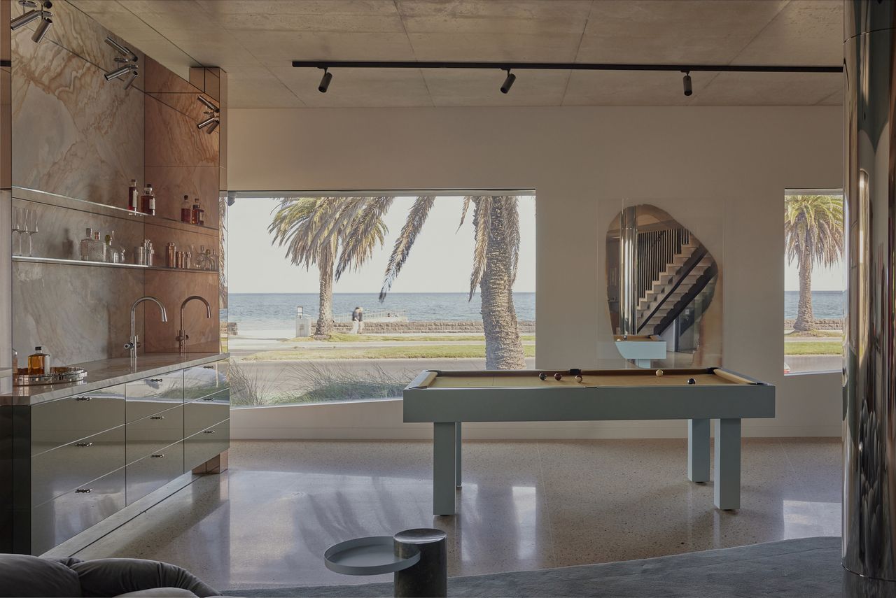 games room with windows looking out to the beach, with home bar and pool table