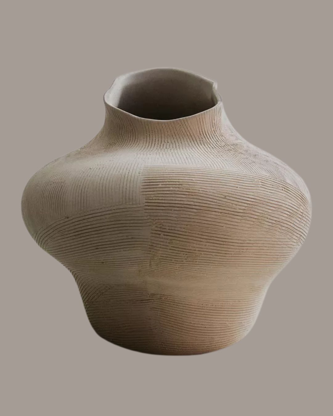 Irregular Ceramic Vase against pale brown background.