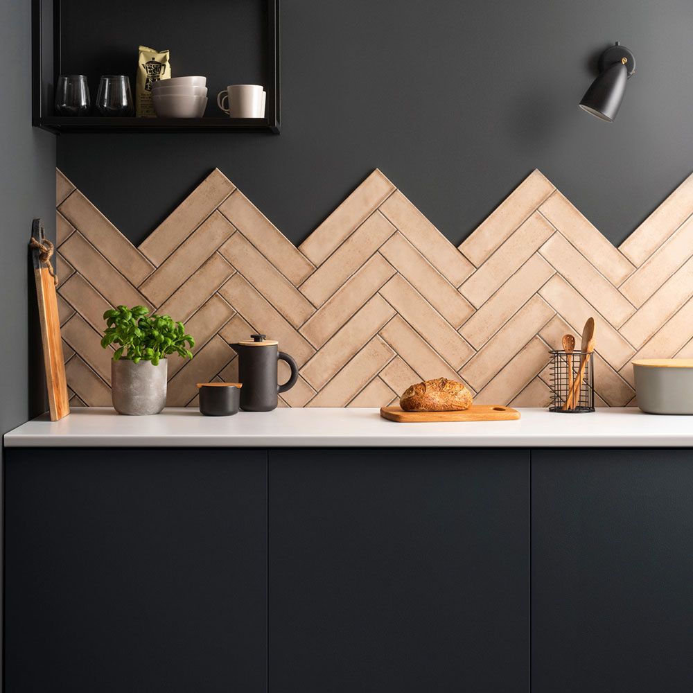 pink herringbone tiles in a dark kitchen