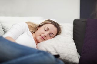 A woman naps on a couch.