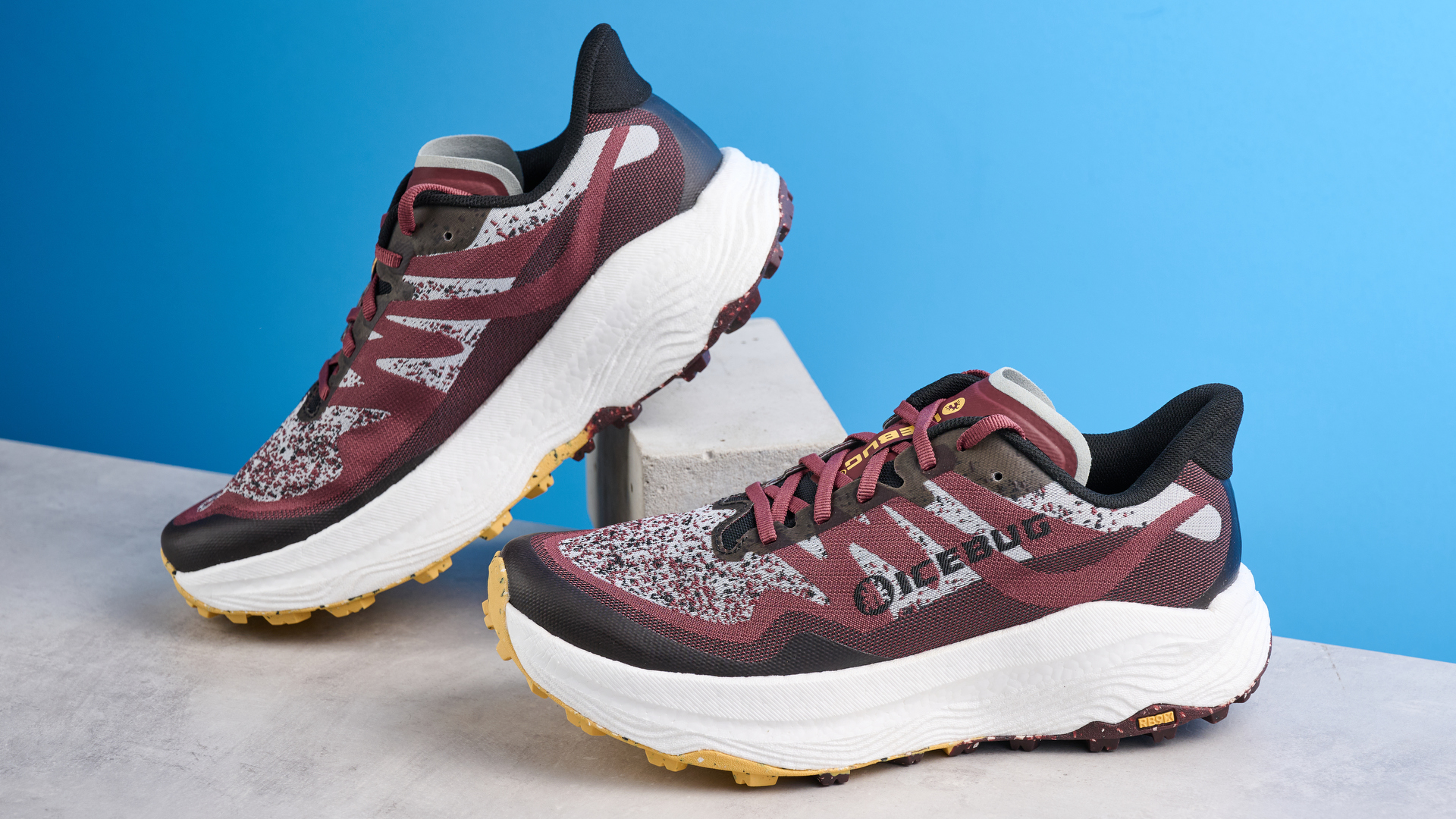 the icebug j&auml;rv rb9x trail running shoes in cherry and banana photographed against the tom's guide blue background