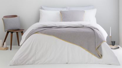 Best bedding Made.com white bedding on bed with yellow trim cushions and accessories 