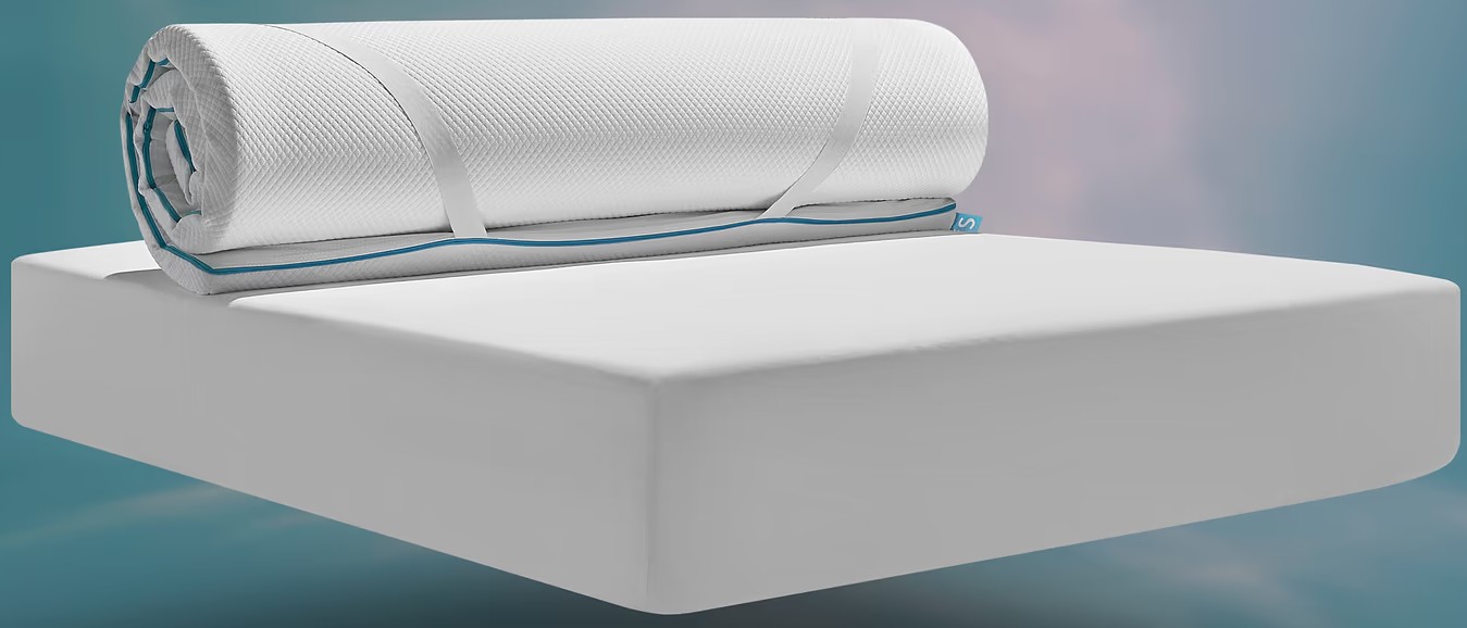 The Simba Cool Foam Mattress Topper rolled up and partially unrolled on top of a white mattress against a soft teal and pink gradient background.