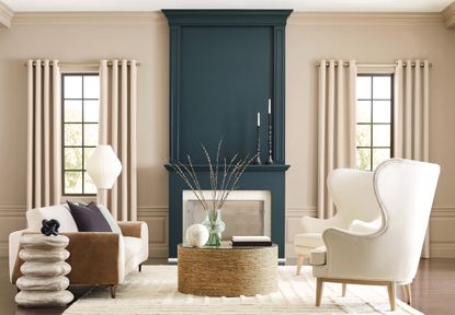 A neutral living room with white sofa and chairs and a dark blue painted fireplace