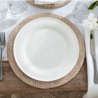 The White Company Symons Bone China Dinner Plate, on a placemat, with a knife and fork either side.