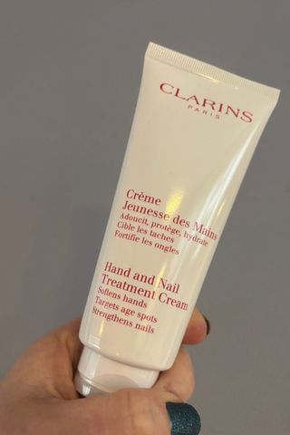 shot of clarins hand cream being held