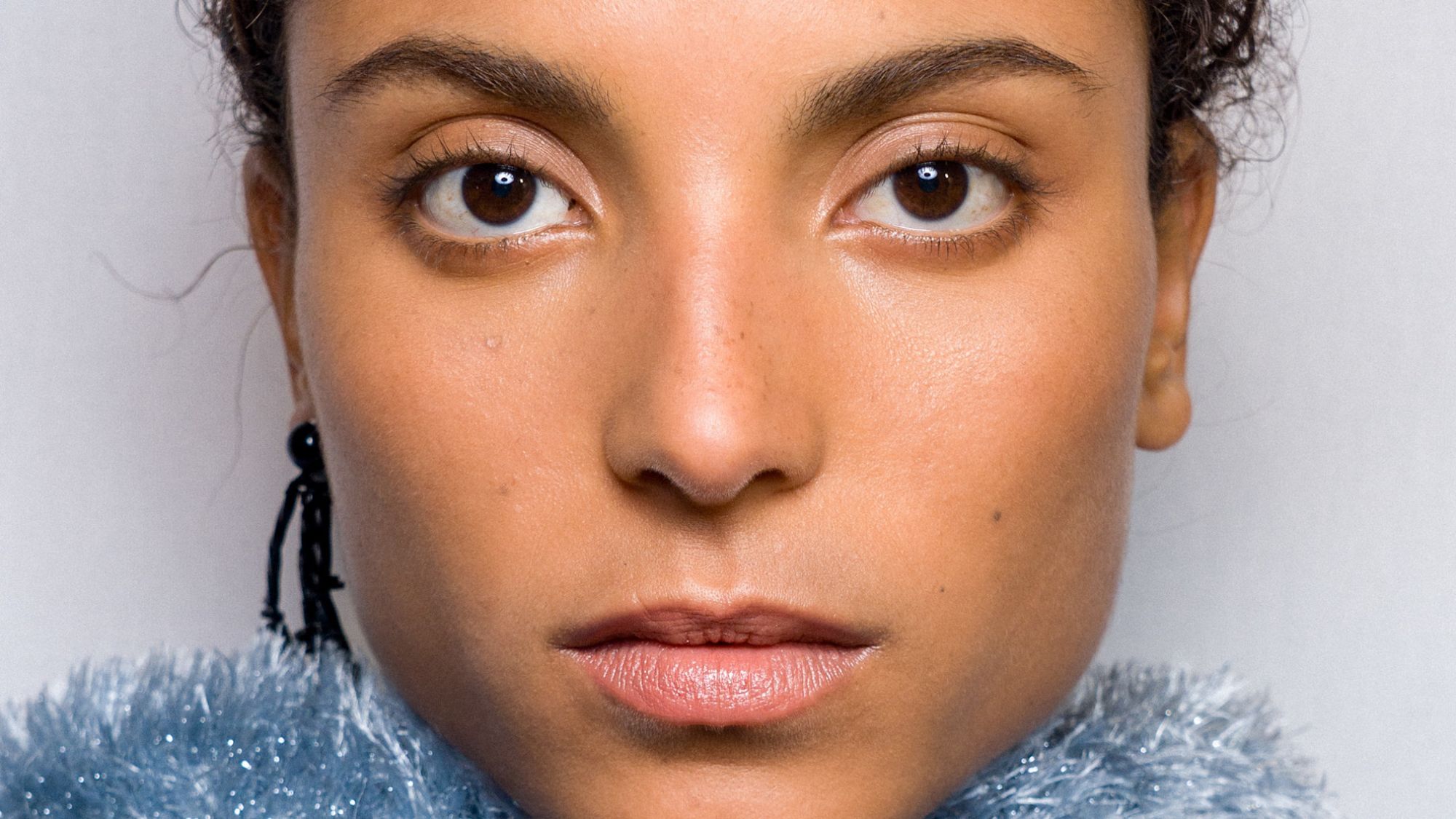 A close up of a model's face backstage at the Cfcl show - lactic acid