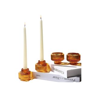 Woho Candlestick Holders in amber on a book