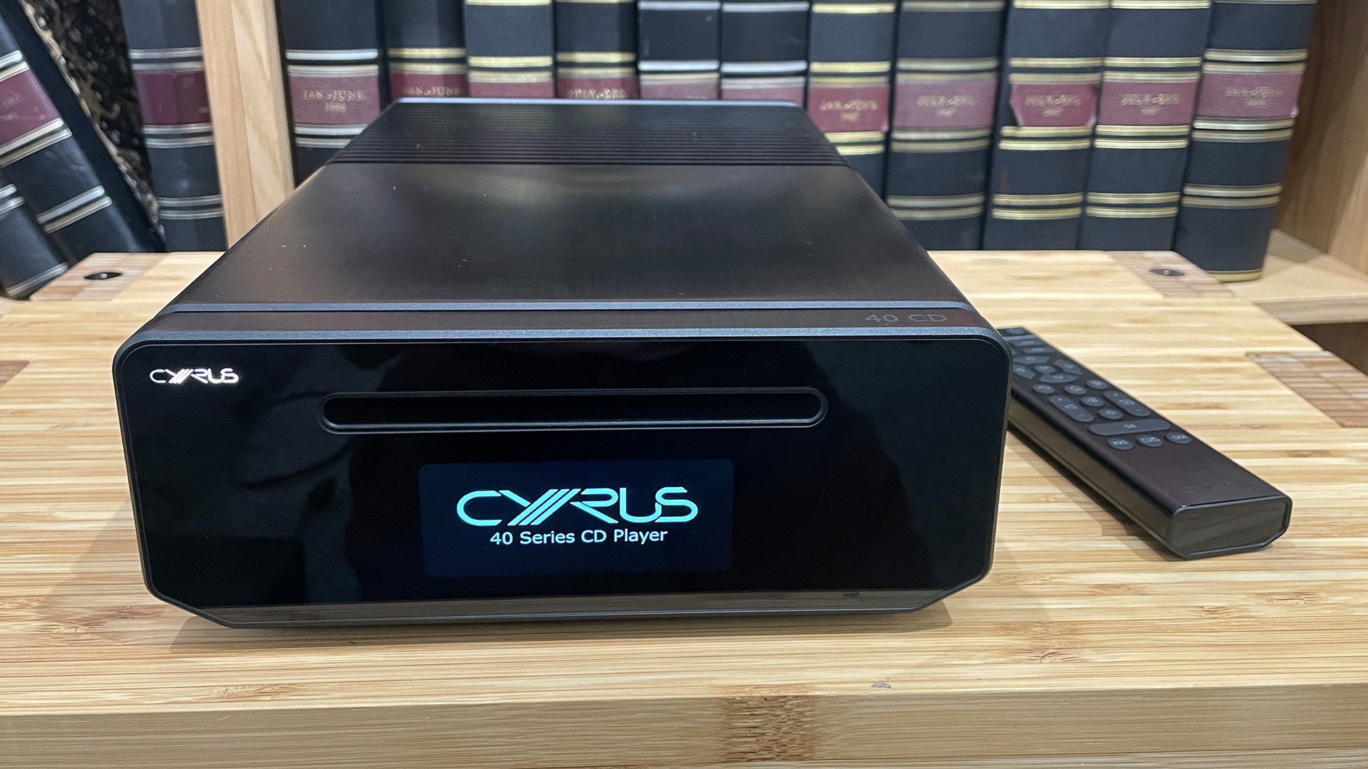 Cyrus 40 CD CD player on wooden hi-fi rack in front of bookcase displaying Cyrus on display