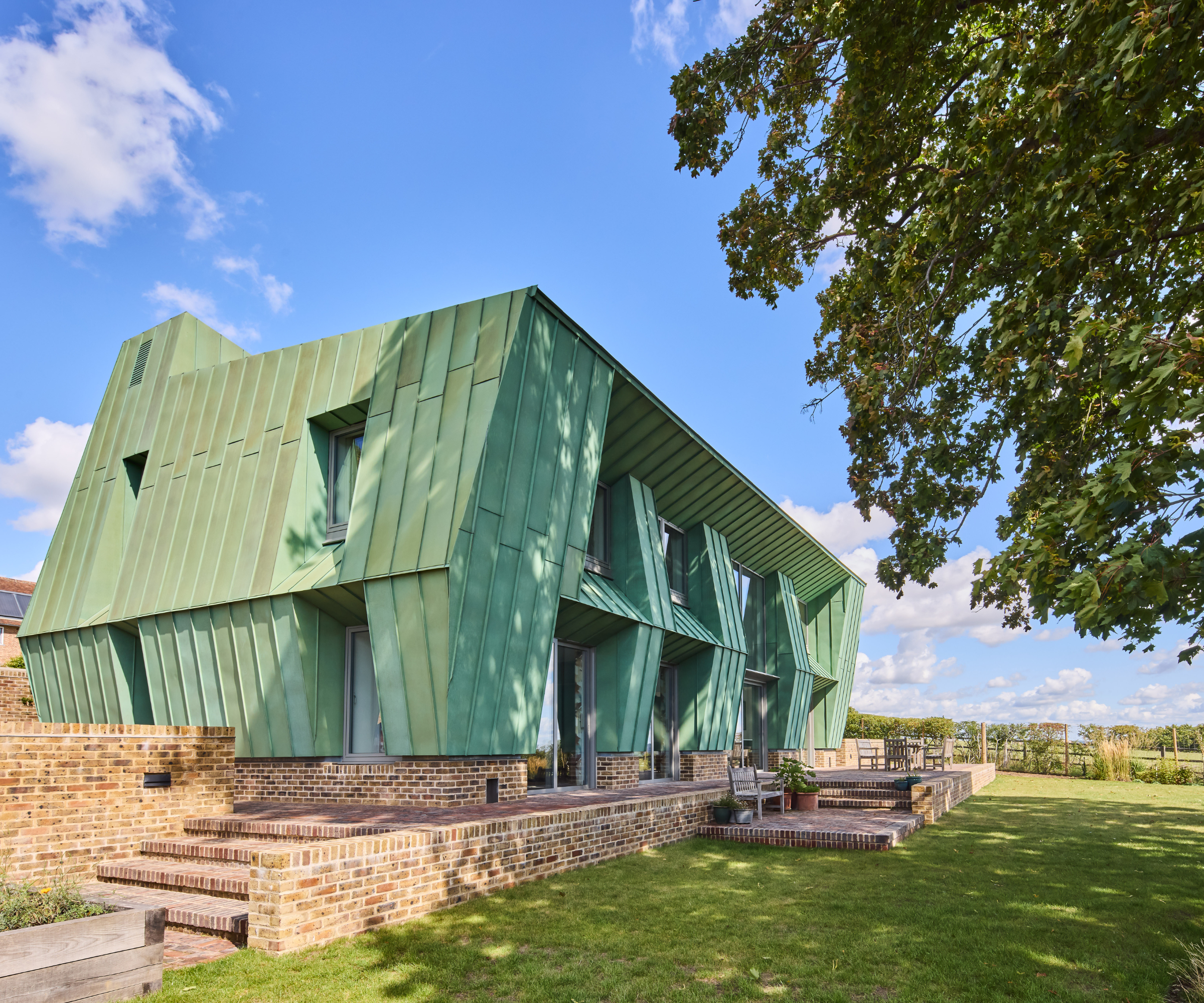 Exterior of green house with lawn and brick patio