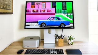 Mac Studio on a desk plugged into a Studio Display