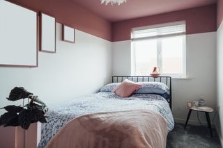 A white bedroom with a pink painted dropped ceiling.