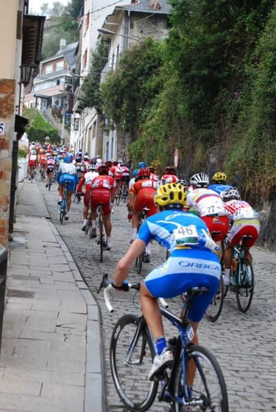 Riders at the back of the peloton struggle on a cobbled climb