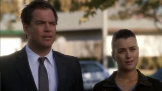 Tony and Ziva standing outside talking to a victim on NCIS
