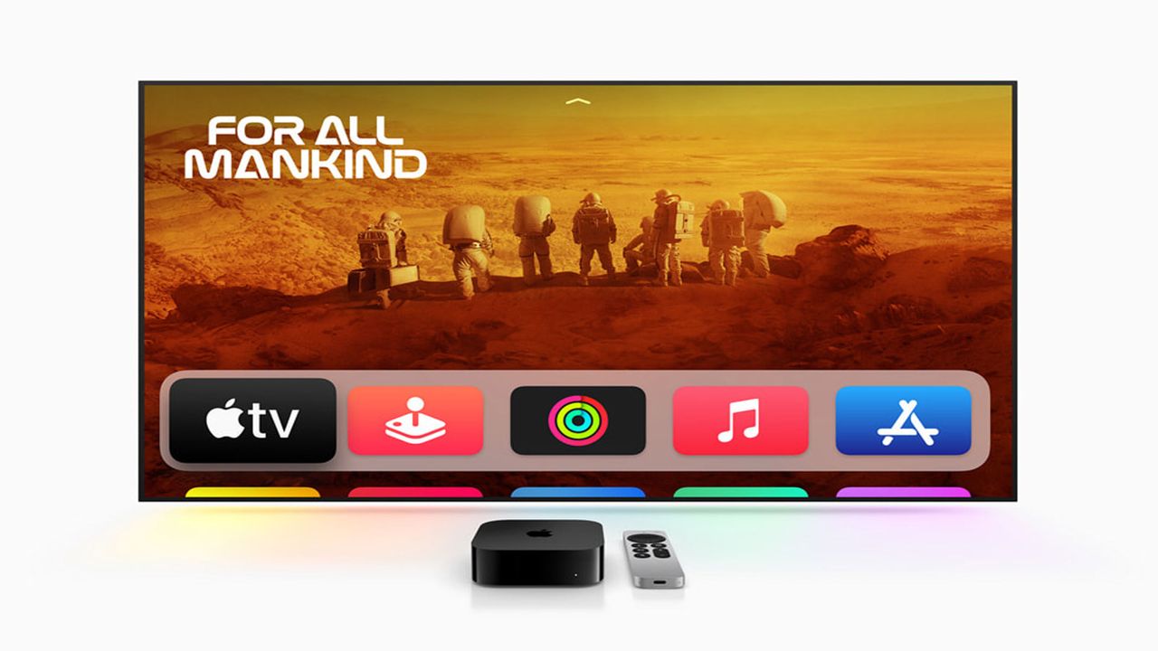 A black box is next to a silver remote controller infront of a TV screen with several options to select on it.