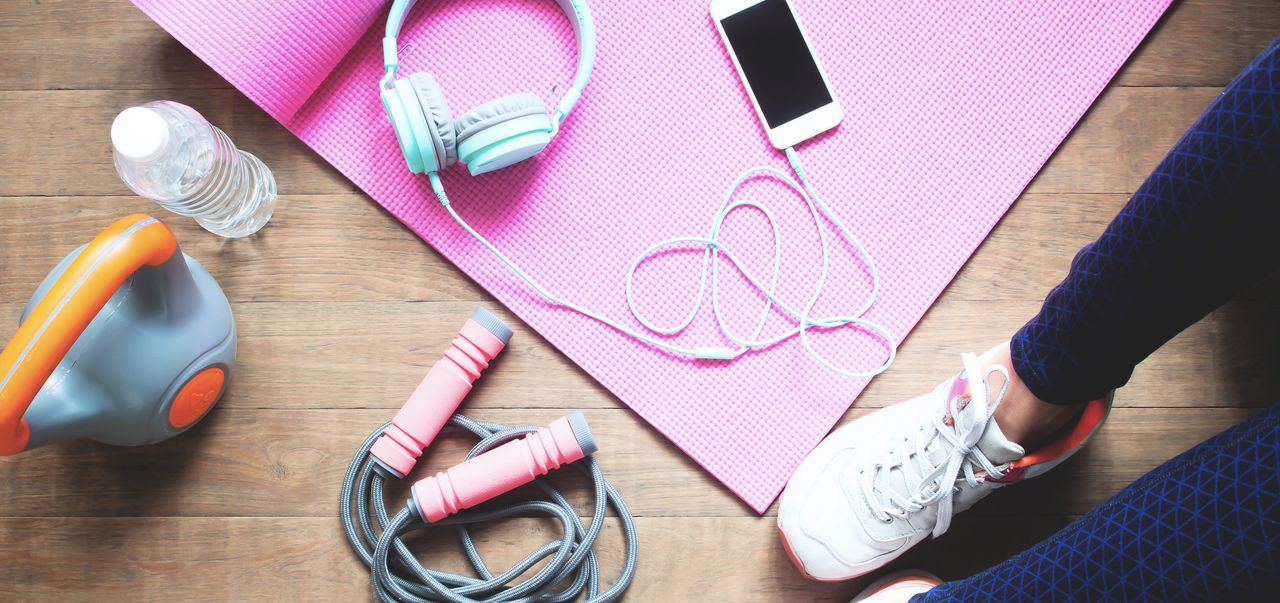 activewear accessories - Low Section Of Woman With Exercise Equipment Sitting On Hardwood Floor