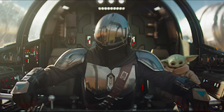 a helmeted space pilot with a baby green alien in a spaceship