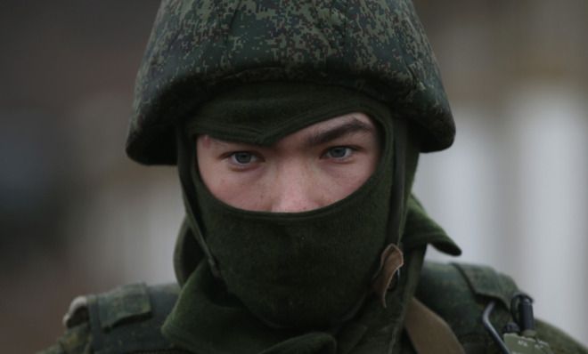 A soldier stands guard near a military base in Crimea