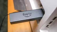 Amazon Fire TV Stick 4K Max, одно из лучших потоковых устройств, горизонтально подключенное к телевизору.