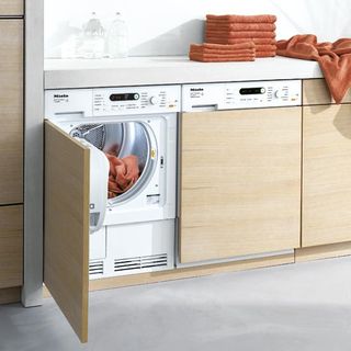 tumble dryer with clothes and white flooring